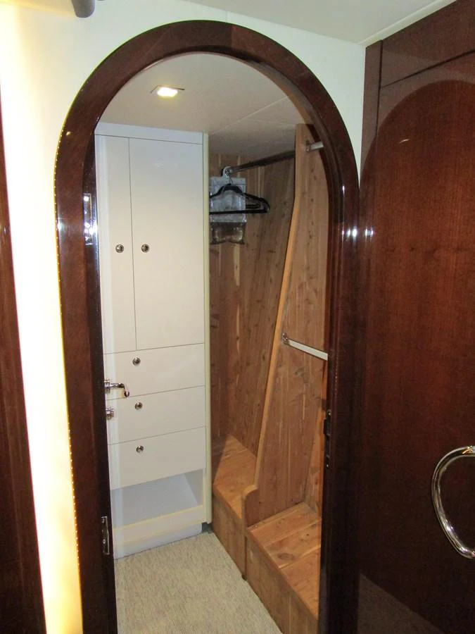 A cozy and well-appointed closet area with wooden finishes and ample storage space. aboard SHORE GIRL Yacht for Sale