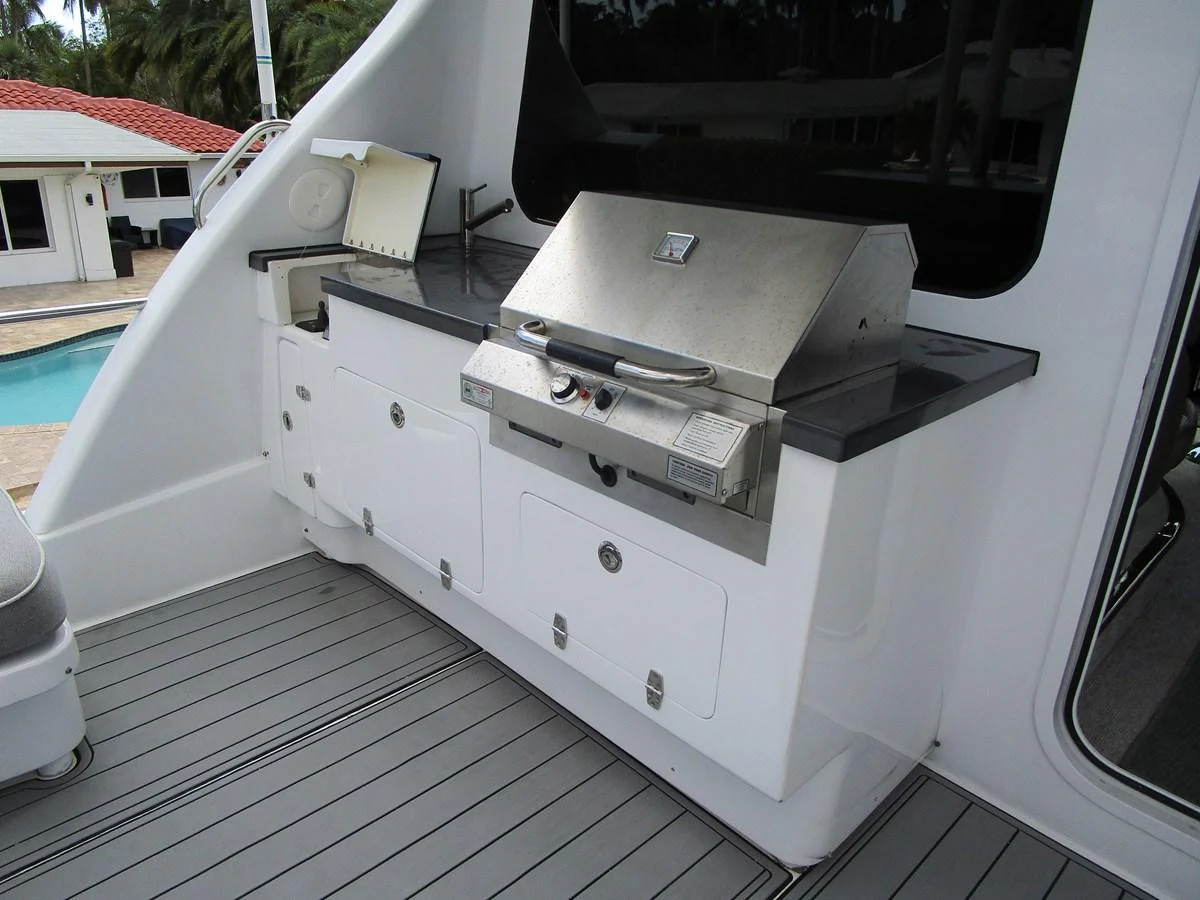This image showcases a well-equipped outdoor galley with a stainless steel grill and ample storage space. aboard SHORE GIRL Yacht for Sale