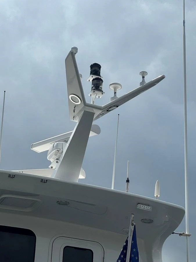 The image showcases the yacht's radar and communication equipment against a cloudy sky. aboard SHORE GIRL Yacht for Sale