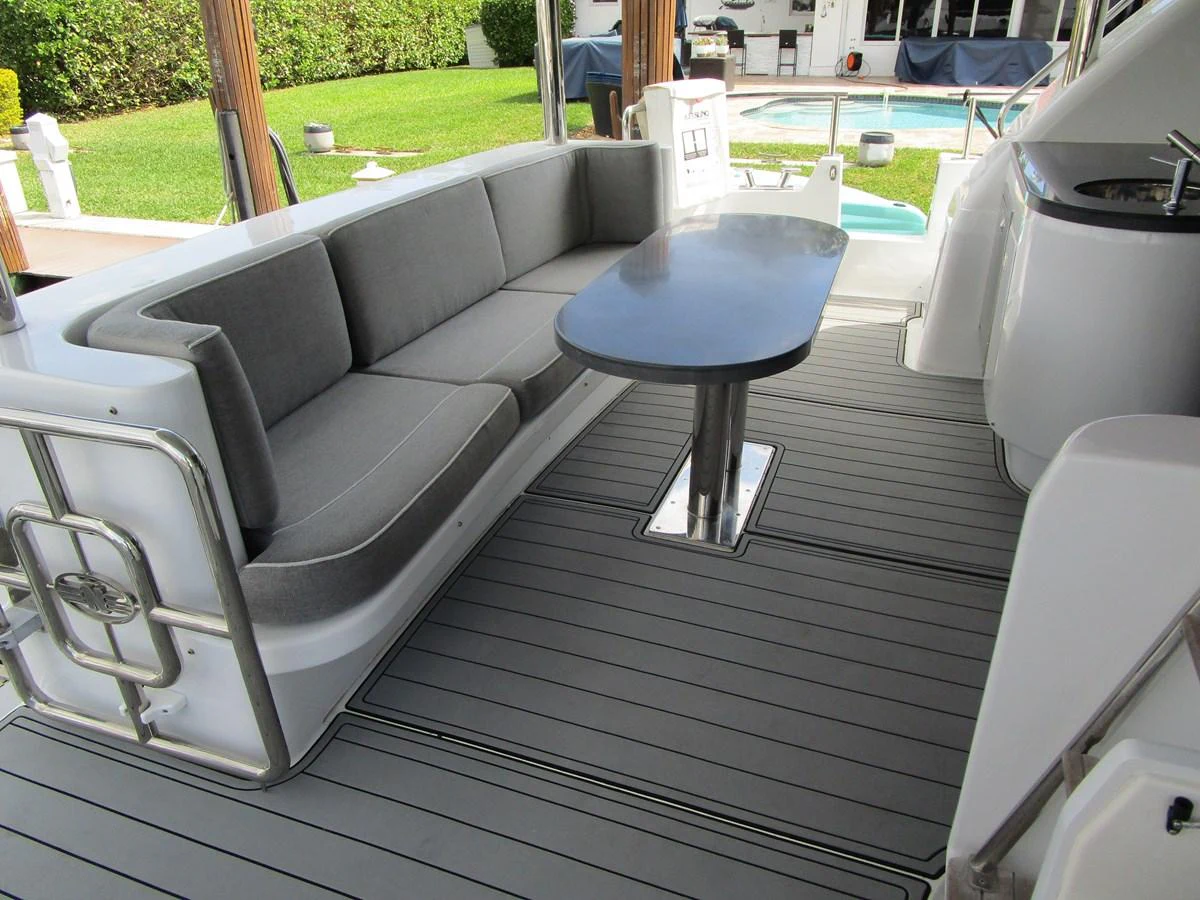 The aft deck features a comfortable seating area with a sleek table, perfect for outdoor relaxation. aboard SHORE GIRL Yacht for Sale
