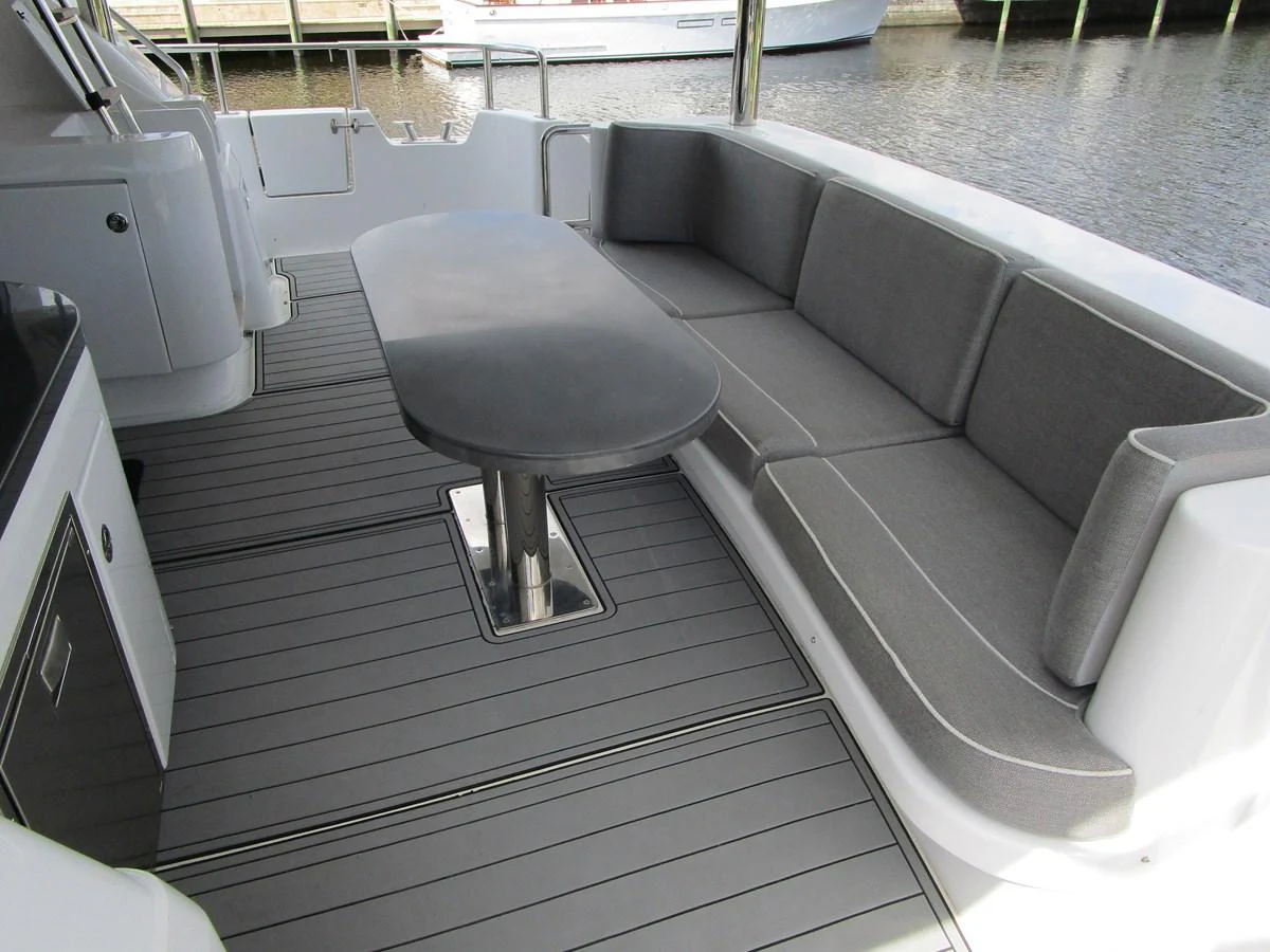 The aft deck features a comfortable seating area with a sleek table, perfect for outdoor relaxation and dining. aboard SHORE GIRL Yacht for Sale