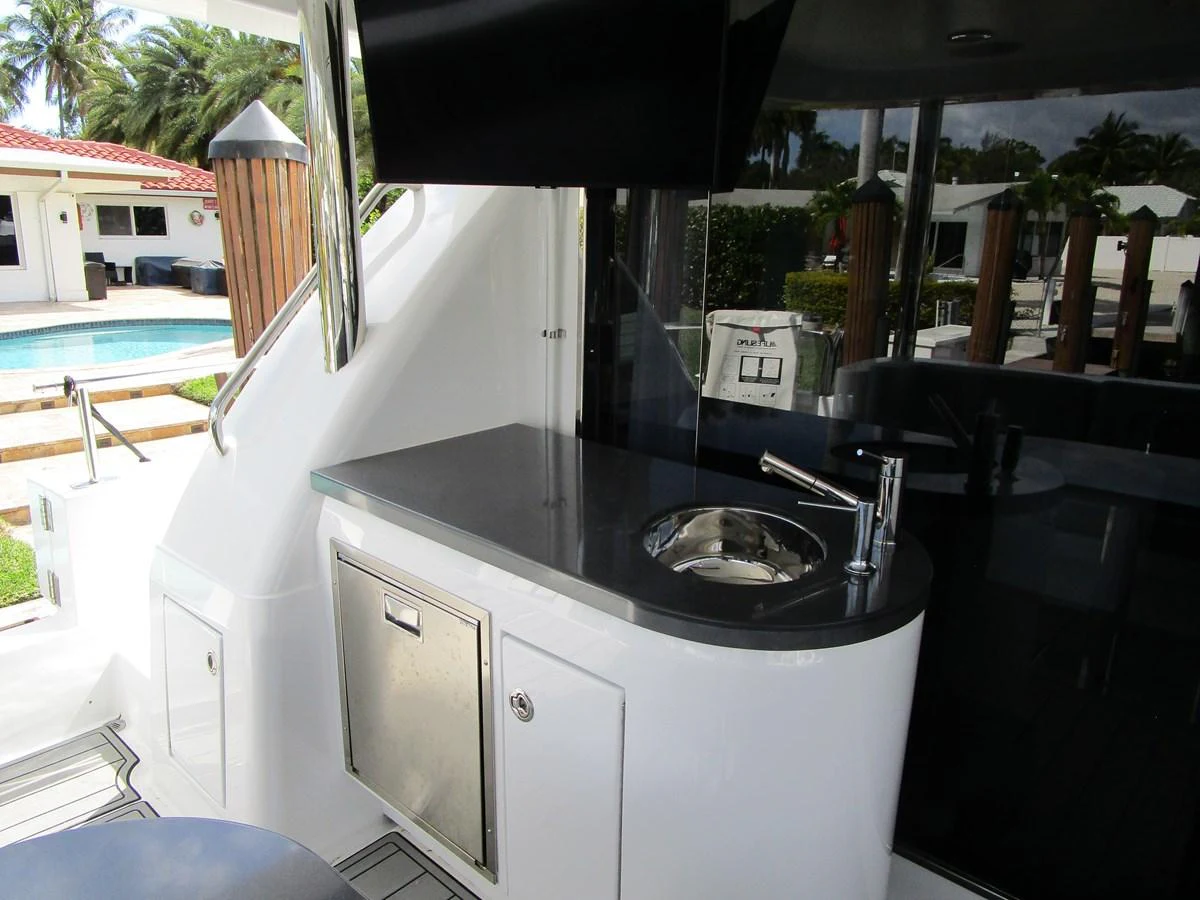 A sleek wet bar area on a yacht, featuring a sink, countertop, and storage. aboard SHORE GIRL Yacht for Sale