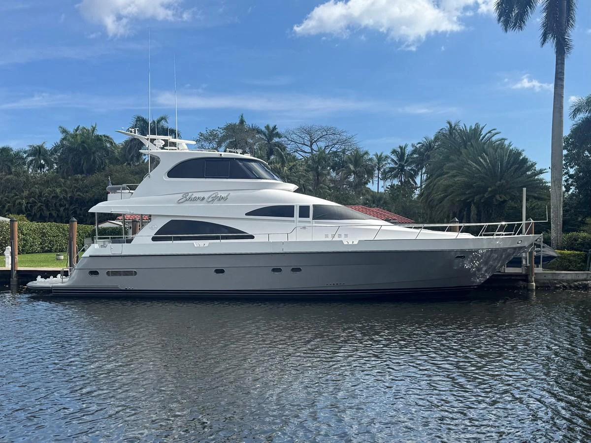 A sleek yacht is docked in a serene marina, showcasing its elegant design and modern lines. aboard SHORE GIRL Yacht for Sale
