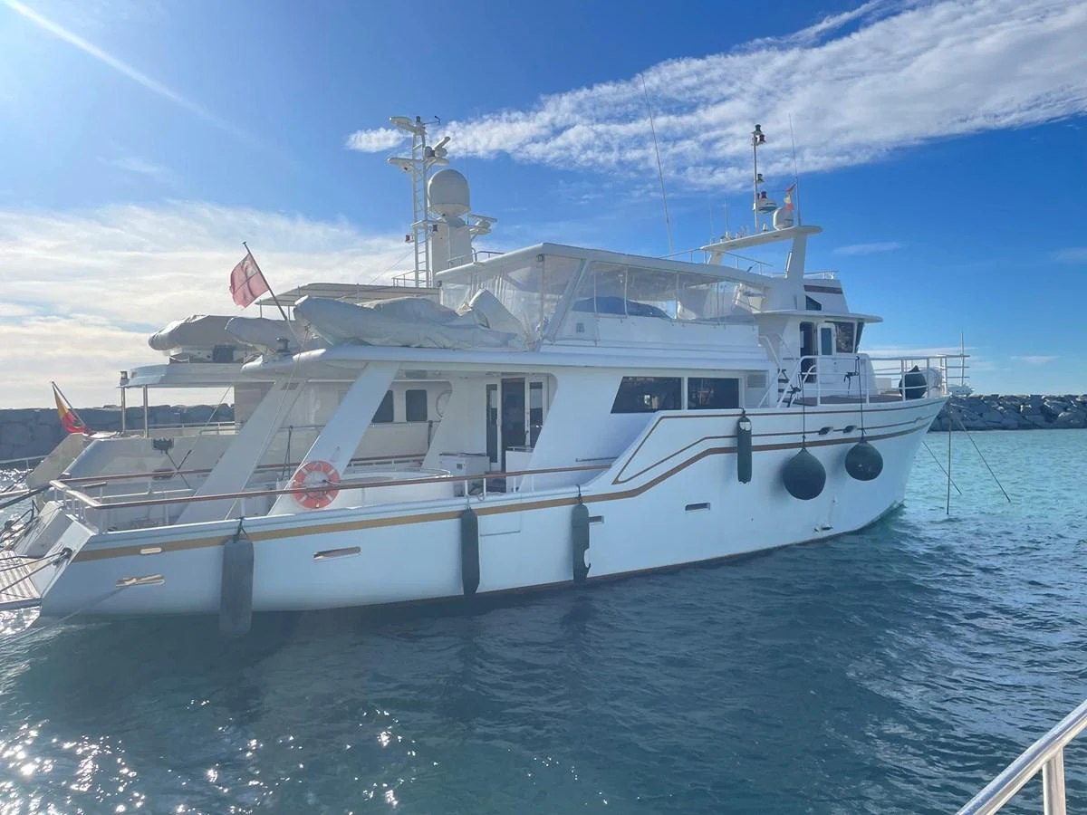 A luxurious yacht is docked in a serene marina under a clear blue sky. aboard ATB MAROC  CUSTOM MOTOR YACHT Yacht for Sale