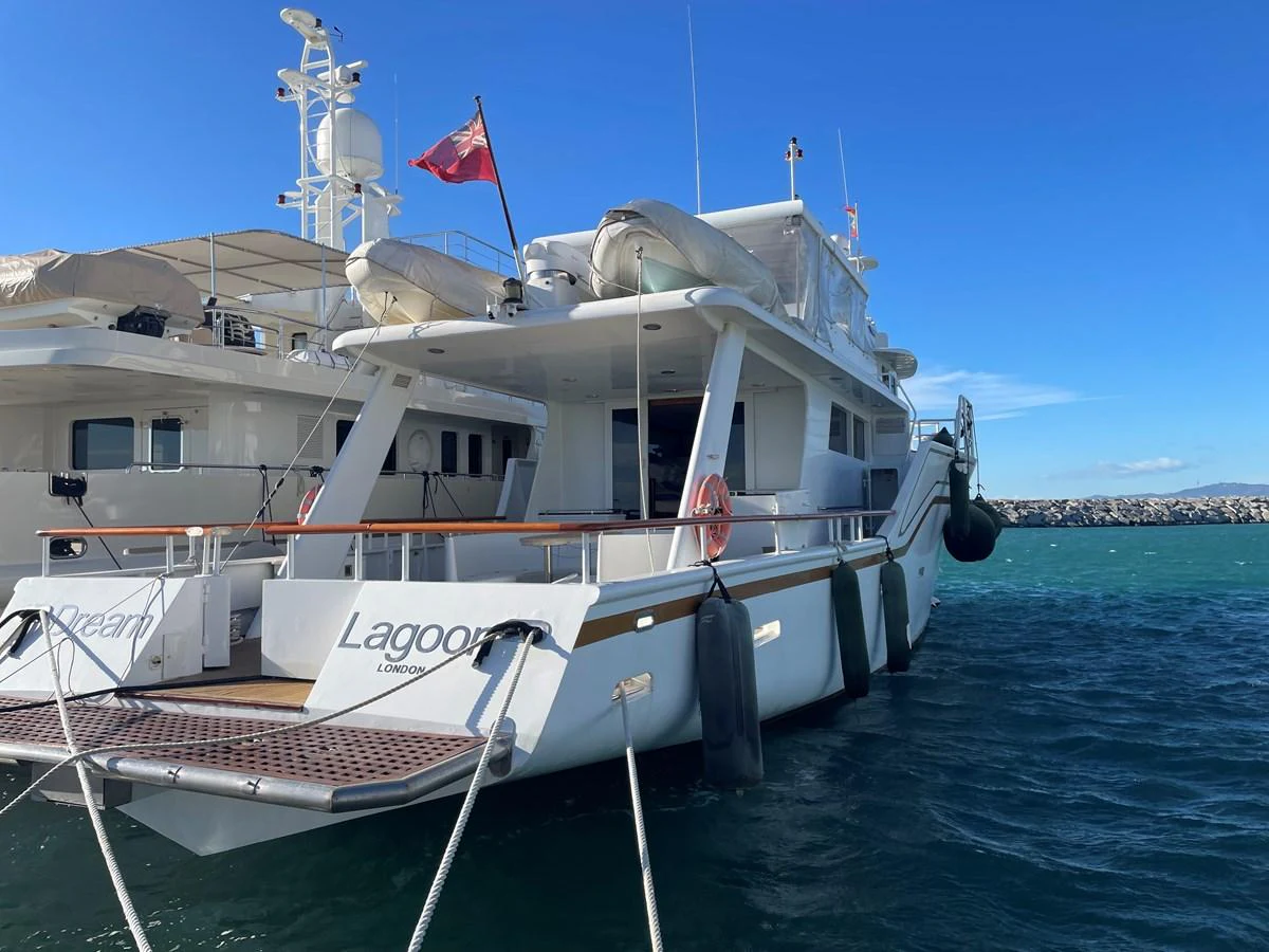 The yacht is docked at a marina, showcasing its spacious aft deck and sleek design. aboard ATB MAROC  CUSTOM MOTOR YACHT Yacht for Sale