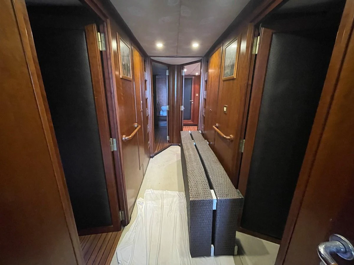 A hallway with wooden paneling and ambient lighting leads to various rooms on the yacht. aboard ATB MAROC  CUSTOM MOTOR YACHT Yacht for Sale