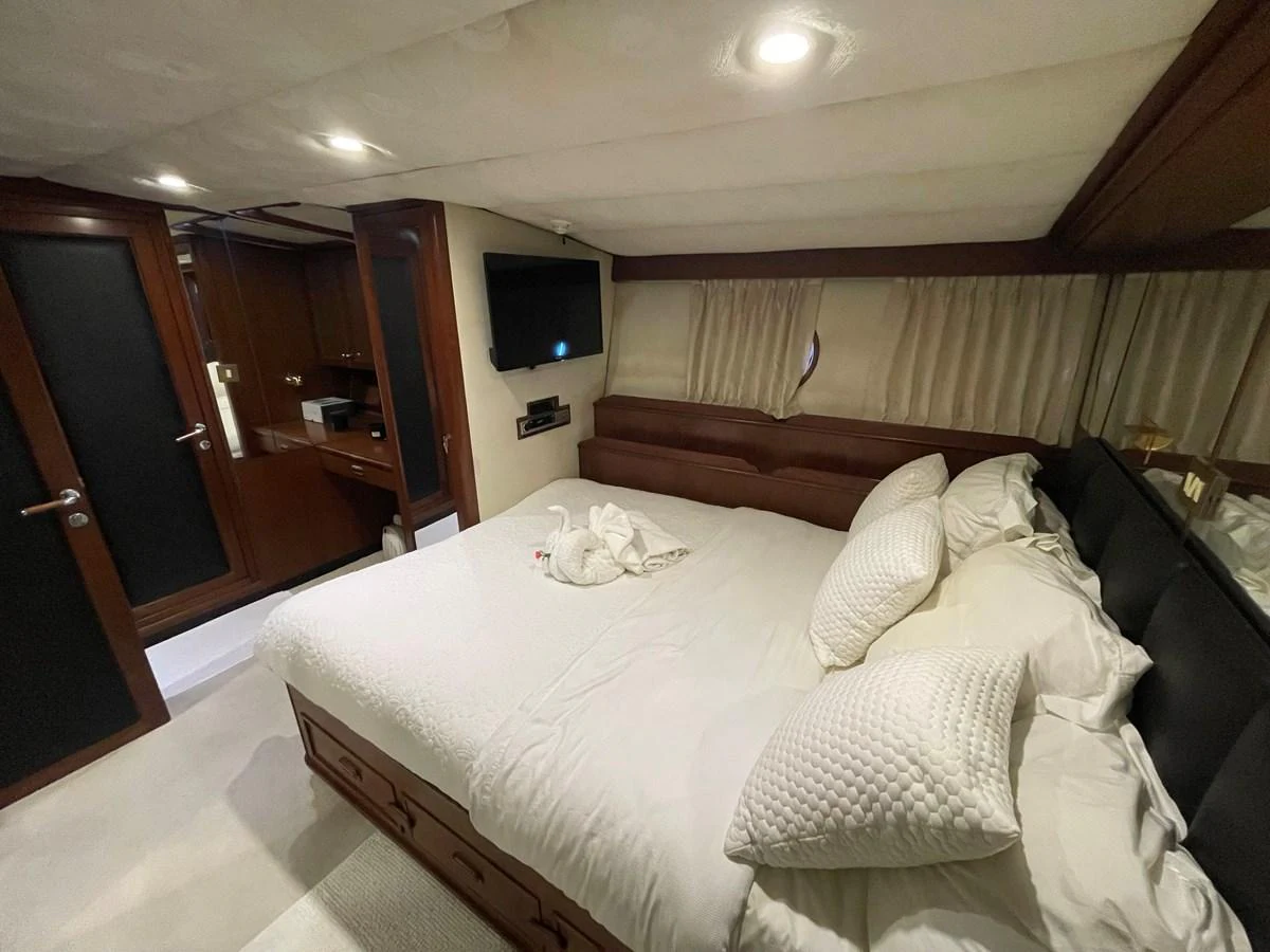 The stateroom features a cozy bed with plush pillows and a wall-mounted TV, creating a comfortable and inviting space. aboard ATB MAROC  CUSTOM MOTOR YACHT Yacht for Sale