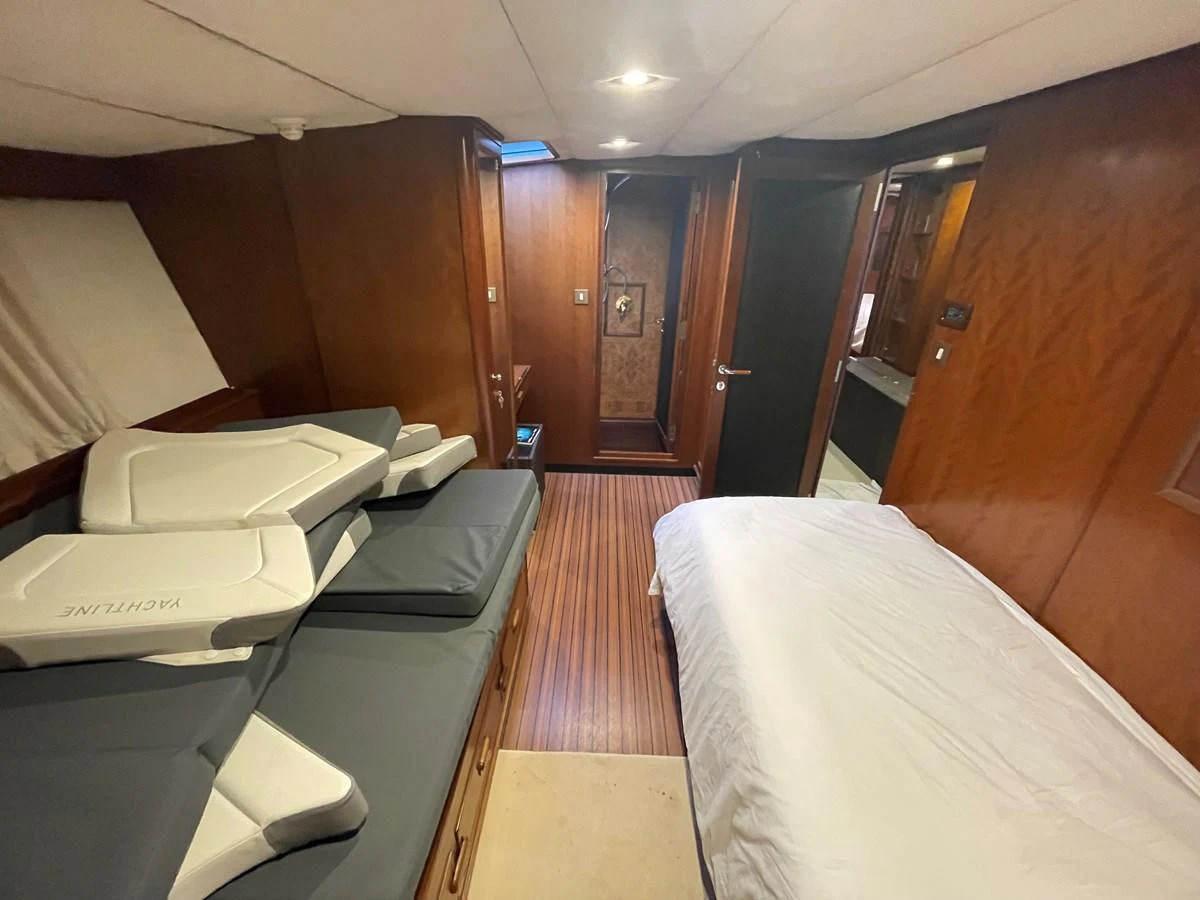 A cozy cabin with a bed and seating area, featuring warm wooden paneling and soft lighting. aboard ATB MAROC  CUSTOM MOTOR YACHT Yacht for Sale