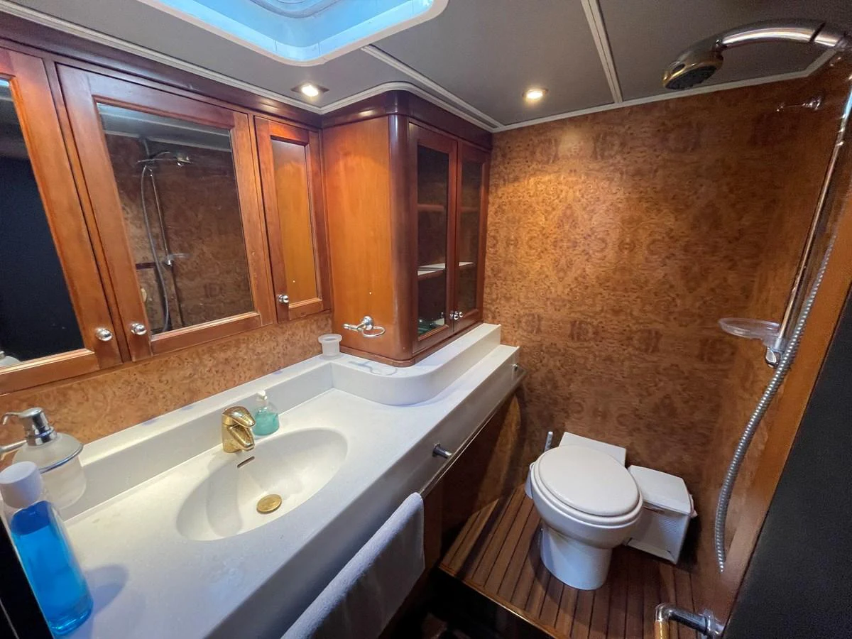 The yacht's bathroom features elegant wood cabinetry, a modern sink, and a spacious shower area. aboard ATB MAROC  CUSTOM MOTOR YACHT Yacht for Sale