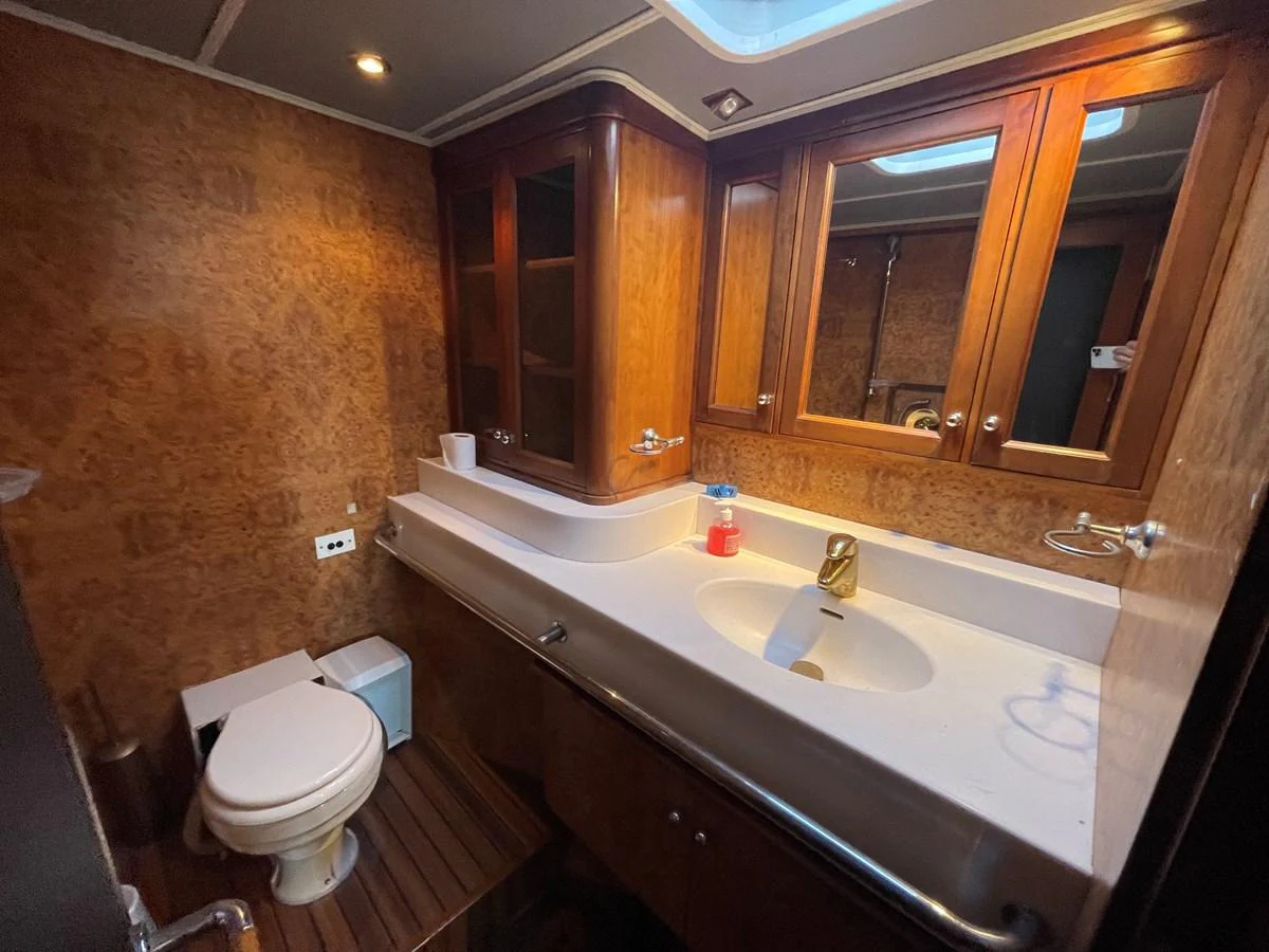 The yacht's bathroom features elegant wood paneling and a spacious countertop with a modern sink. aboard ATB MAROC  CUSTOM MOTOR YACHT Yacht for Sale