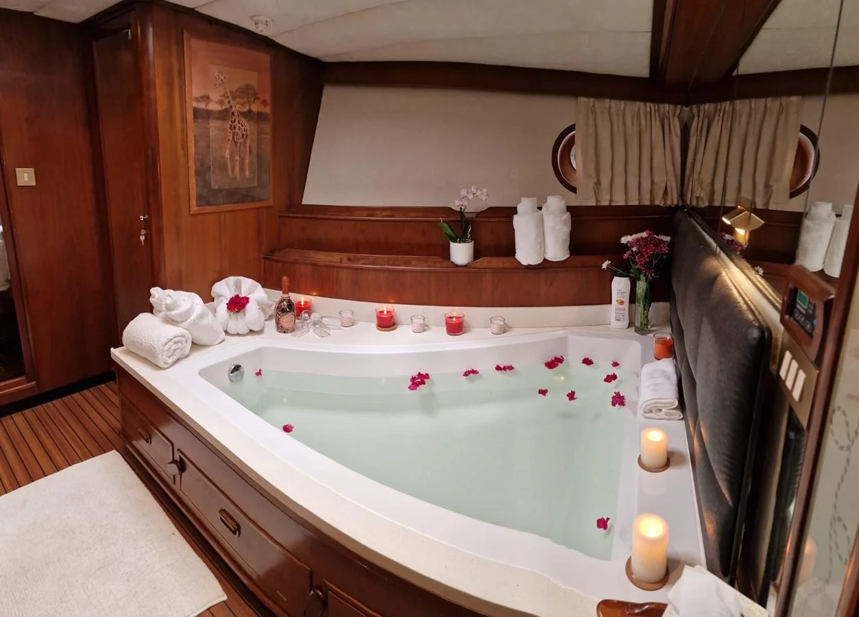 A luxurious yacht bathroom featuring a large bathtub adorned with rose petals and surrounded by candles. aboard ATB MAROC  CUSTOM MOTOR YACHT Yacht for Sale