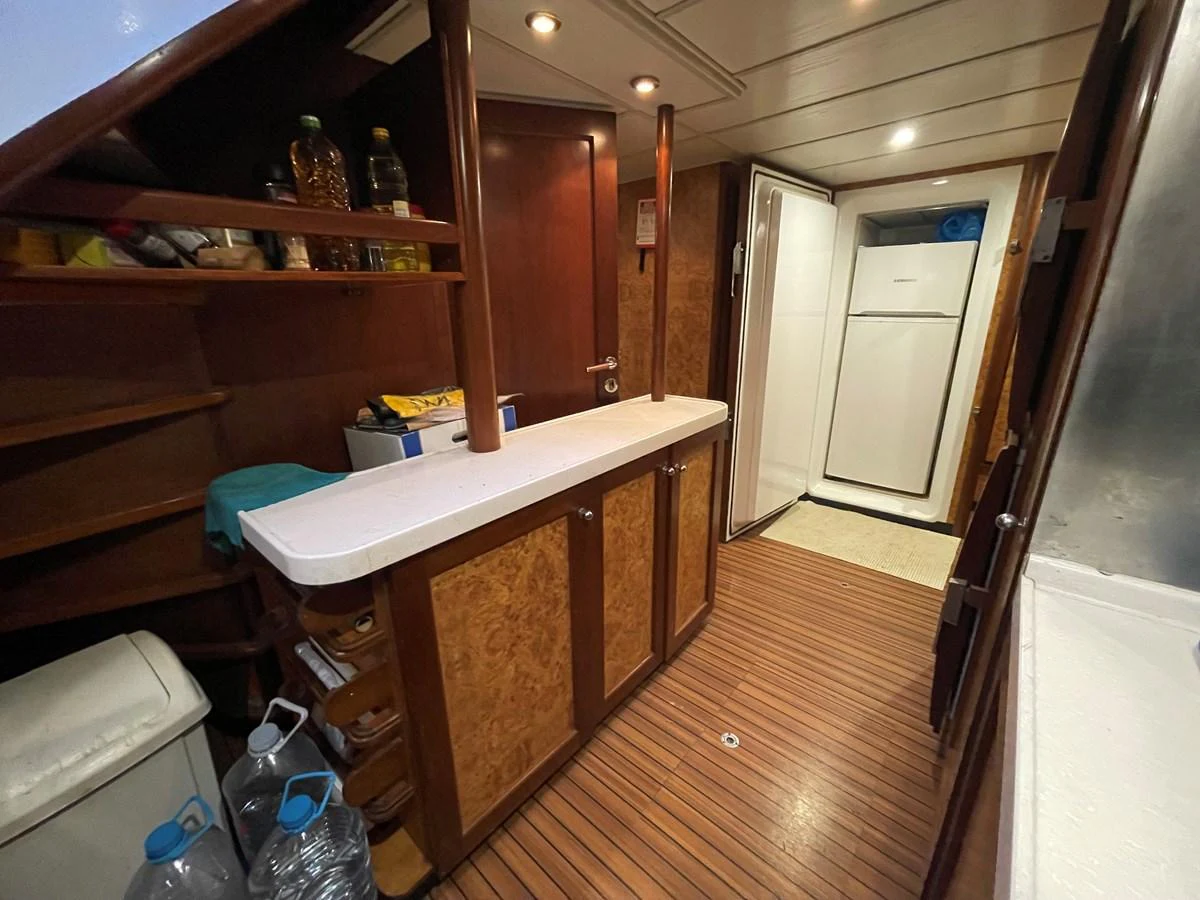 The galley features wooden cabinetry, a white countertop, and modern appliances. aboard ATB MAROC  CUSTOM MOTOR YACHT Yacht for Sale