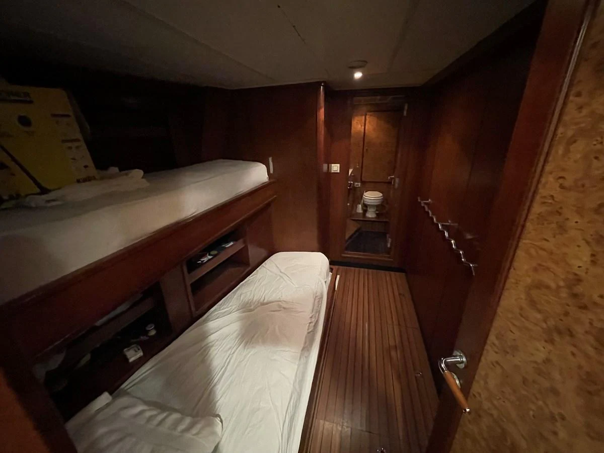 A cozy cabin with bunk beds and a view into the ensuite bathroom. aboard ATB MAROC  CUSTOM MOTOR YACHT Yacht for Sale