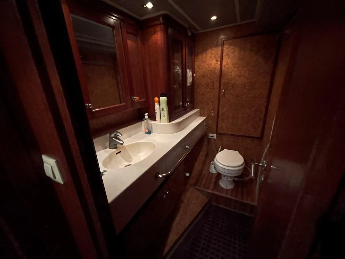 The yacht's bathroom features a sleek sink and a well-maintained toilet with wooden accents. aboard ATB MAROC  CUSTOM MOTOR YACHT Yacht for Sale