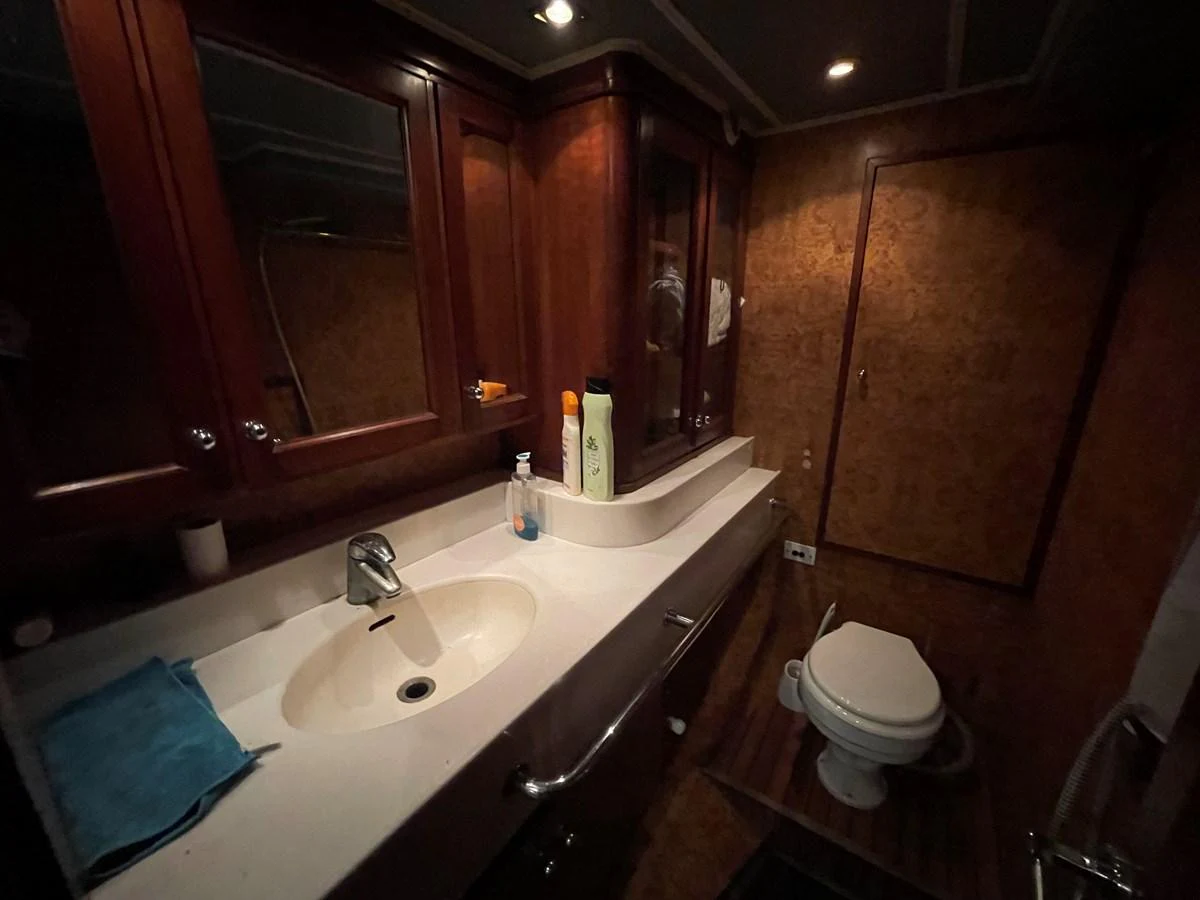 The yacht's bathroom features elegant wood paneling and a sleek countertop with modern fixtures. aboard ATB MAROC  CUSTOM MOTOR YACHT Yacht for Sale