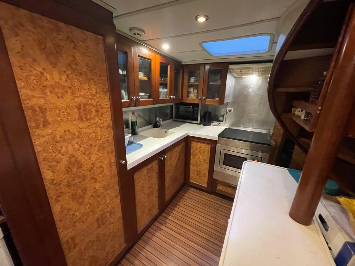 The yacht's galley features warm wood cabinetry, modern appliances, and ample counter space. aboard ATB MAROC  CUSTOM MOTOR YACHT Yacht for Sale
