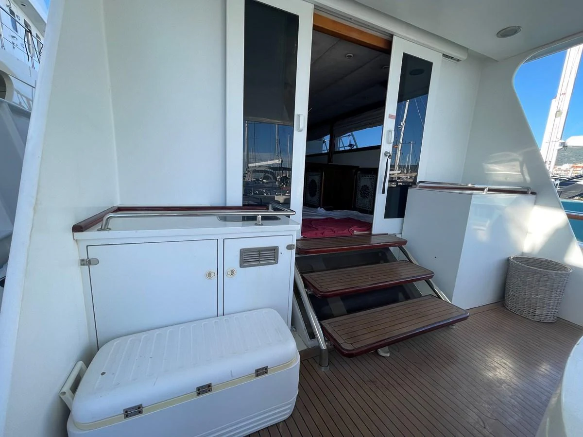 The aft deck features a clean and functional entrance to the yacht's interior, with steps leading up to a glass door. aboard ATB MAROC  CUSTOM MOTOR YACHT Yacht for Sale
