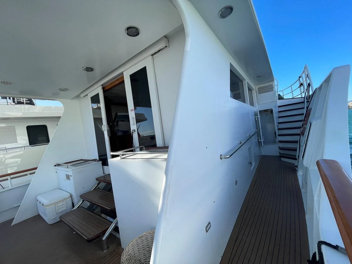 The side deck of the yacht features sleek white walls and wooden flooring, leading to an upper deck via a staircase. aboard ATB MAROC  CUSTOM MOTOR YACHT Yacht for Sale