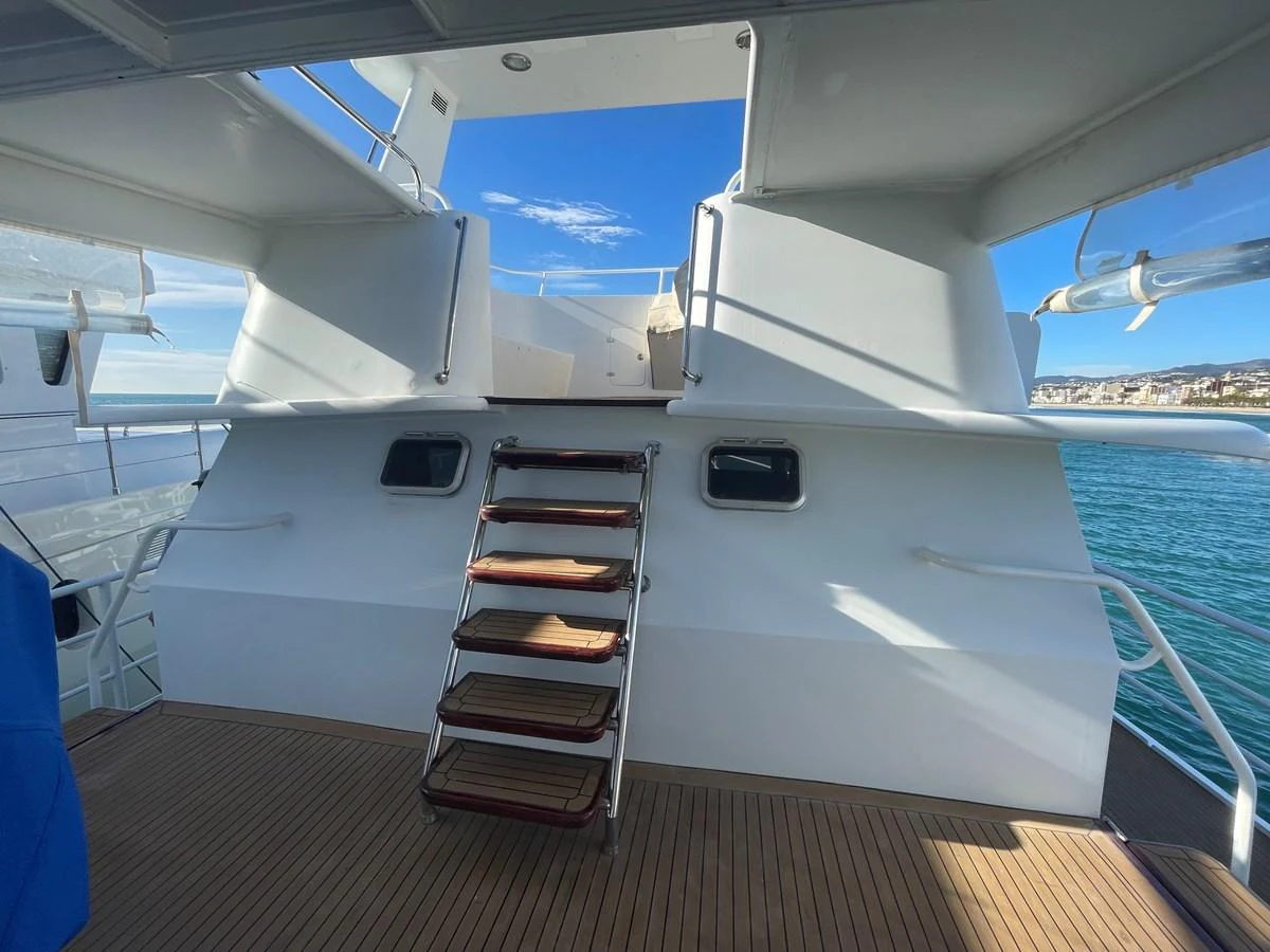 The aft deck features a staircase leading up to the upper deck, with a view of the surrounding waters. aboard ATB MAROC  CUSTOM MOTOR YACHT Yacht for Sale