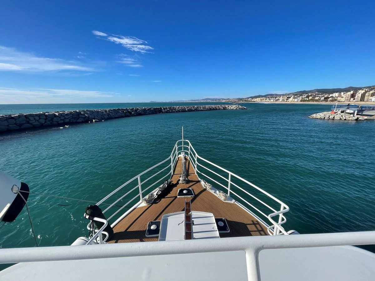 The yacht's bow is seen approaching a marina with a clear view of the surrounding water and coastline. aboard ATB MAROC  CUSTOM MOTOR YACHT Yacht for Sale