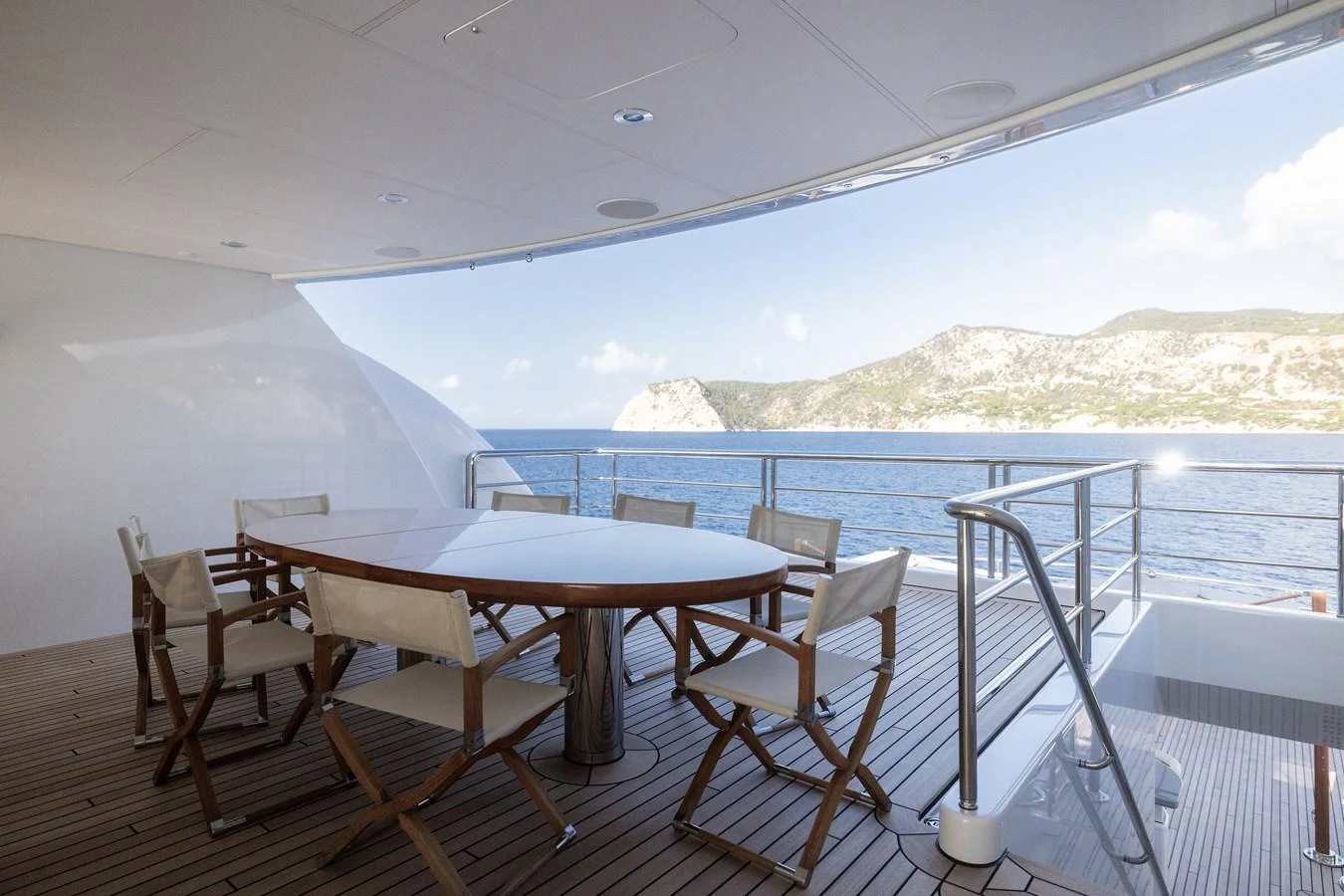 a table and chairs on a deck overlooking a body of water aboard ROCINANTE Yacht for Sale