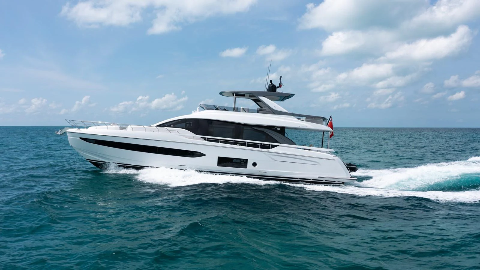 A sleek and modern yacht cruises through the open sea under a partly cloudy sky. aboard EUPHORIA Yacht for Sale