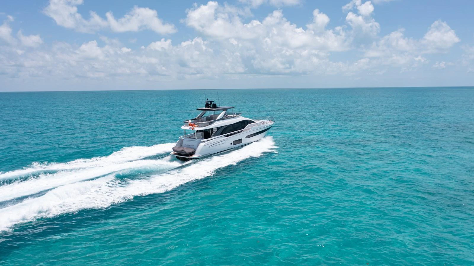 A sleek yacht cruises through turquoise waters under a bright blue sky. aboard EUPHORIA Yacht for Sale