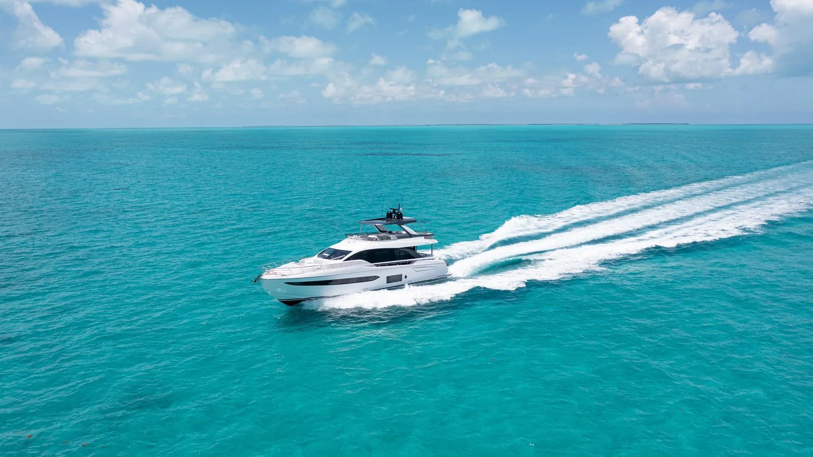 A sleek yacht cruises through vibrant turquoise waters under a clear blue sky. aboard EUPHORIA Yacht for Sale