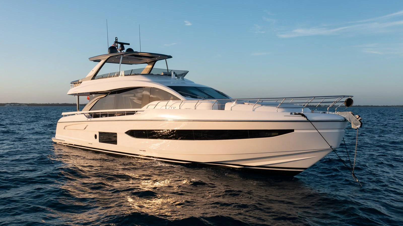 A sleek and modern yacht glides gracefully on calm waters under a clear sky. aboard EUPHORIA Yacht for Sale
