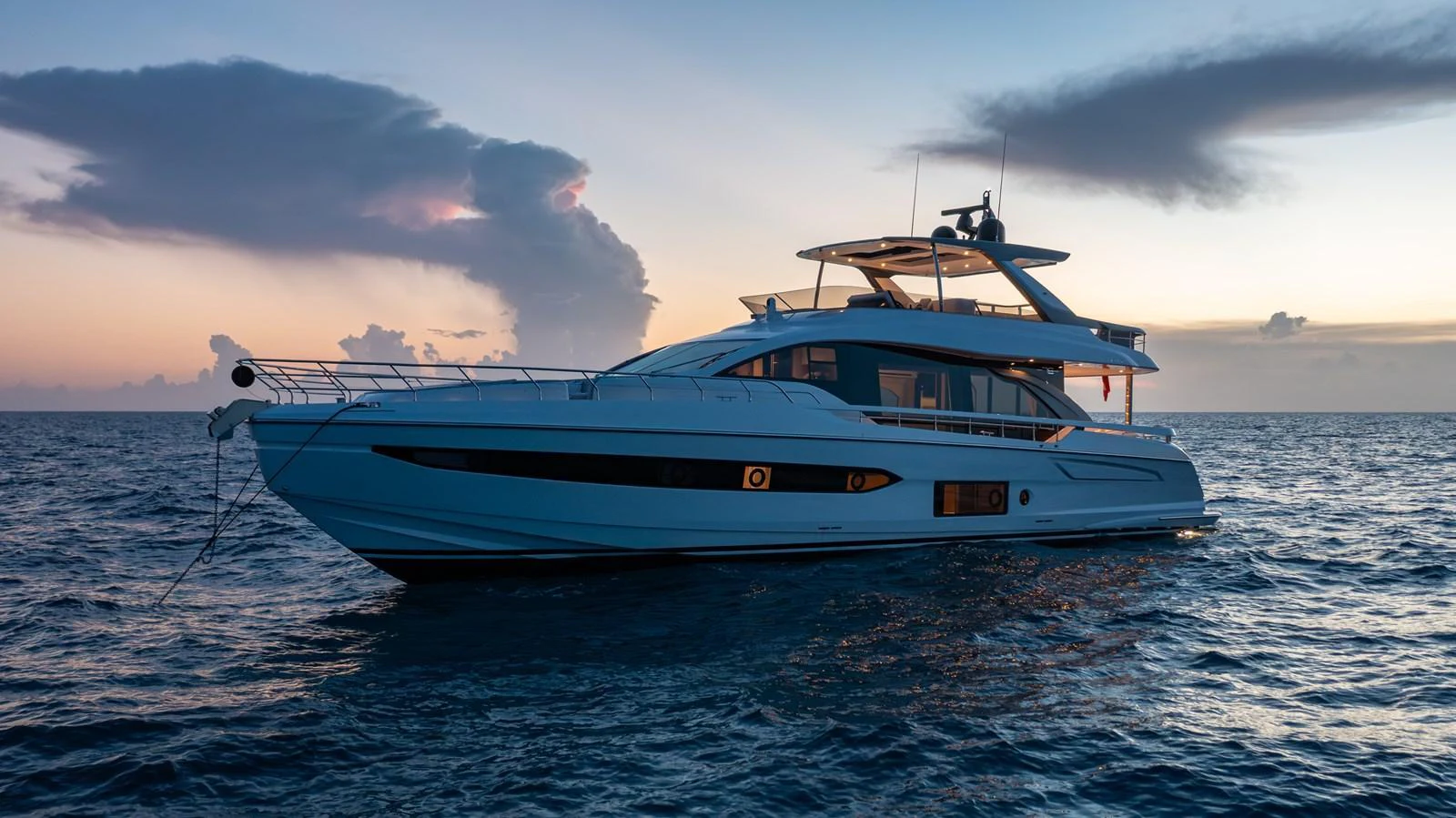 A sleek and modern yacht glides gracefully on the open water at sunset. aboard EUPHORIA Yacht for Sale