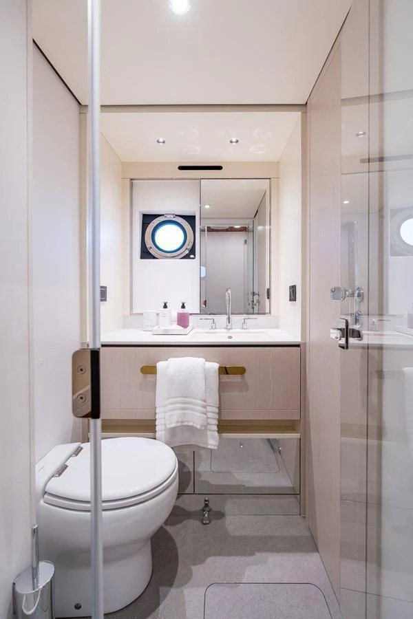 A modern yacht bathroom with sleek fixtures and a porthole window. aboard EUPHORIA Yacht for Sale