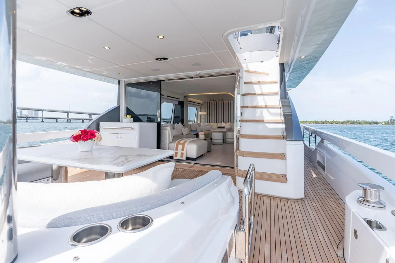 The aft deck features a spacious seating area with a dining table and a view into the luxurious interior. aboard EUPHORIA Yacht for Sale