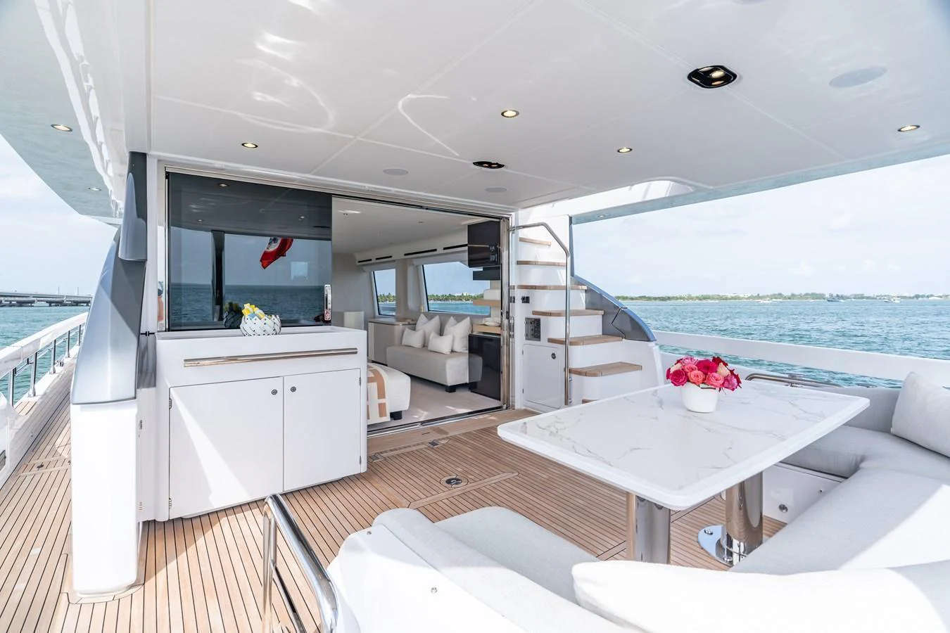 The aft deck offers a spacious and inviting area with comfortable seating and a dining table, seamlessly connecting to the interior living space. aboard EUPHORIA Yacht for Sale