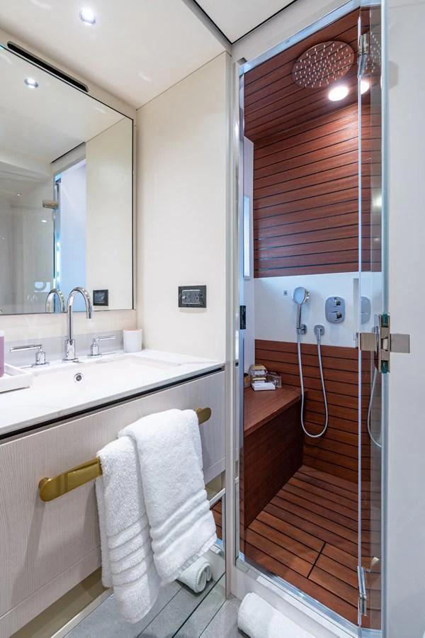 A luxurious yacht bathroom featuring a sleek vanity and a modern shower with wooden accents. aboard EUPHORIA Yacht for Sale