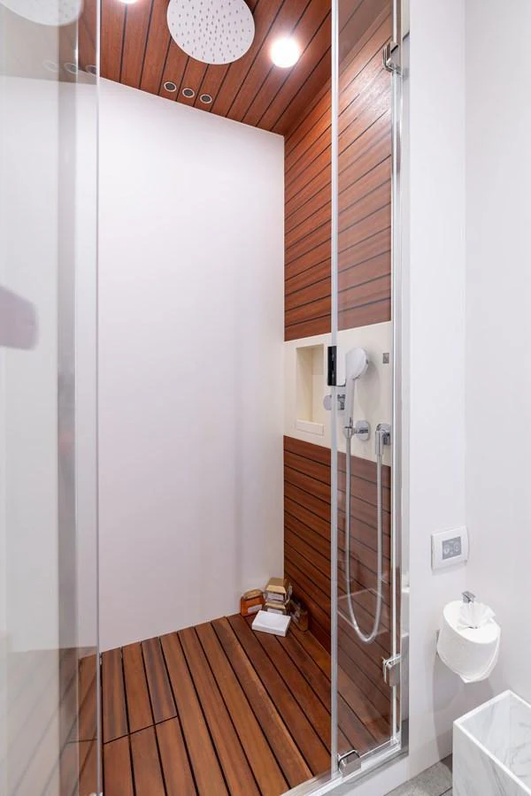 A sleek and modern shower area with wooden accents and contemporary fixtures. aboard EUPHORIA Yacht for Sale