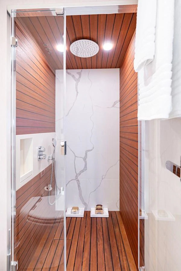 The yacht's bathroom features a sleek design with wooden paneling and a modern shower area. aboard EUPHORIA Yacht for Sale