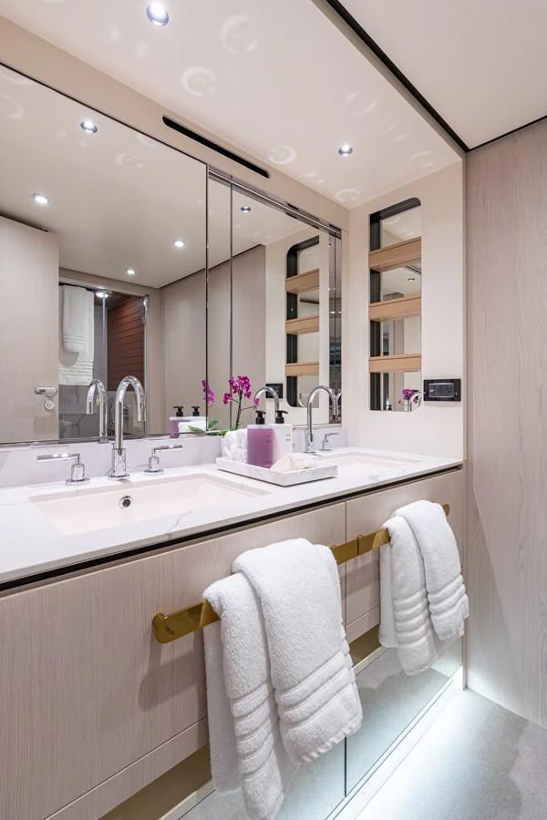 A luxurious yacht bathroom featuring a double vanity with elegant fixtures and soft lighting. aboard EUPHORIA Yacht for Sale