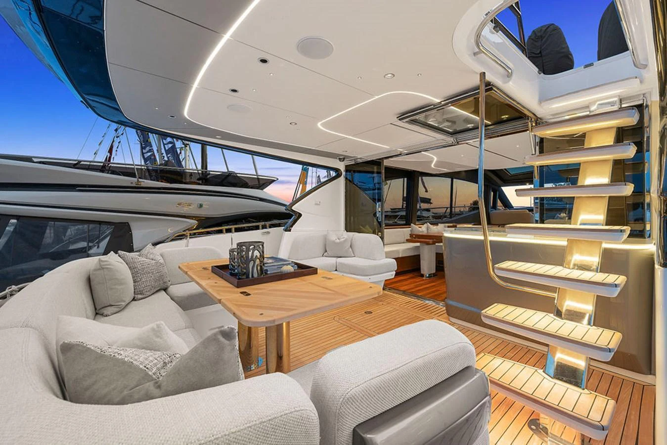 The aft deck features a luxurious seating area with elegant lighting and a staircase leading to the upper deck. aboard PRINCESS S72 Yacht for Sale