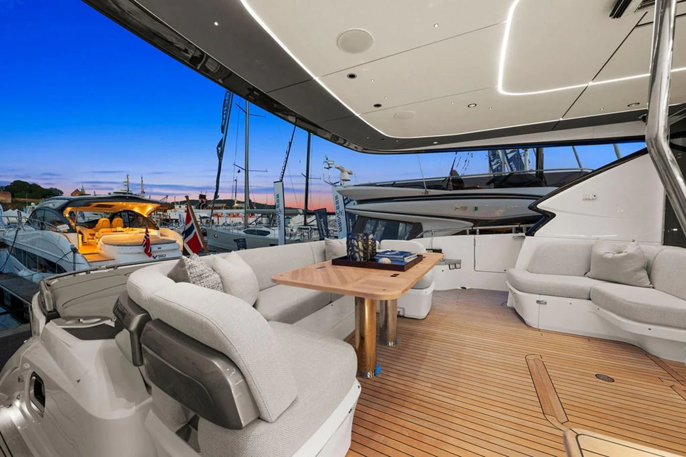 The aft deck offers a spacious and comfortable seating area with a stylish wooden table, perfect for outdoor relaxation and dining. aboard PRINCESS S72 Yacht for Sale