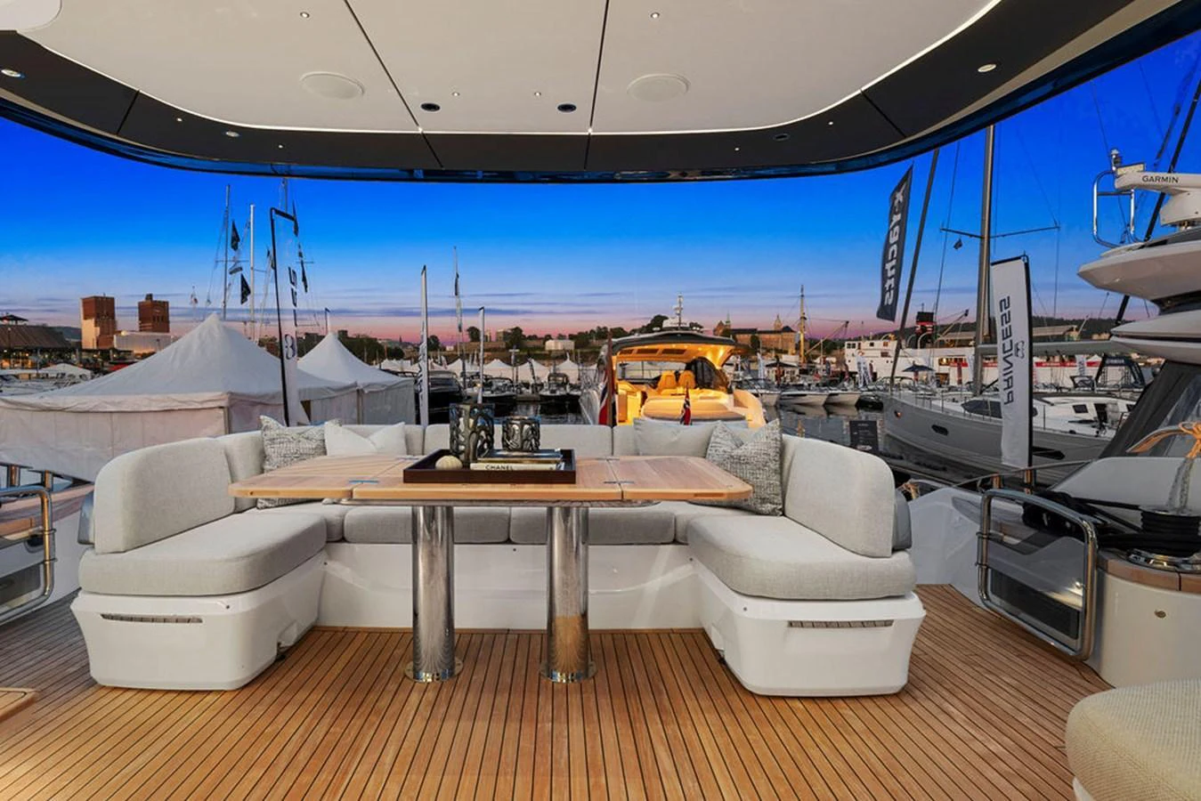 The aft deck features a spacious seating area with a dining table, perfect for enjoying meals with a view of the marina. aboard PRINCESS S72 Yacht for Sale