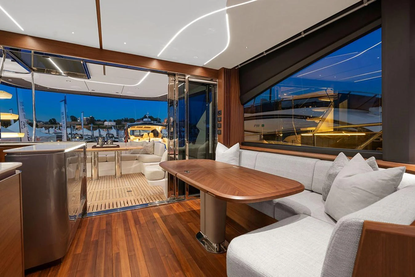 The salon features elegant wood flooring, a comfortable seating area, and large windows offering a view of the marina. aboard PRINCESS S72 Yacht for Sale