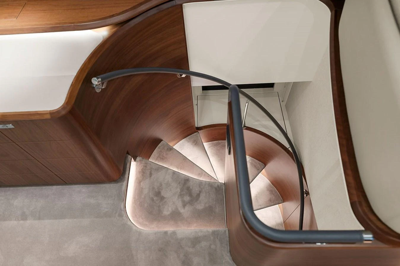 A beautifully crafted wooden staircase with elegant curves and soft lighting. aboard PRINCESS S72 Yacht for Sale