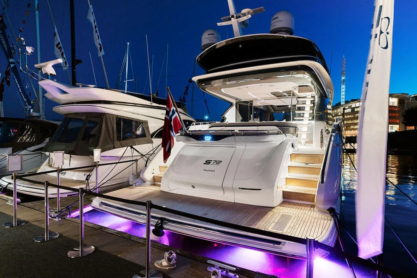 The yacht's illuminated aft deck exudes elegance as it rests docked in a marina at twilight. aboard PRINCESS S72 Yacht for Sale