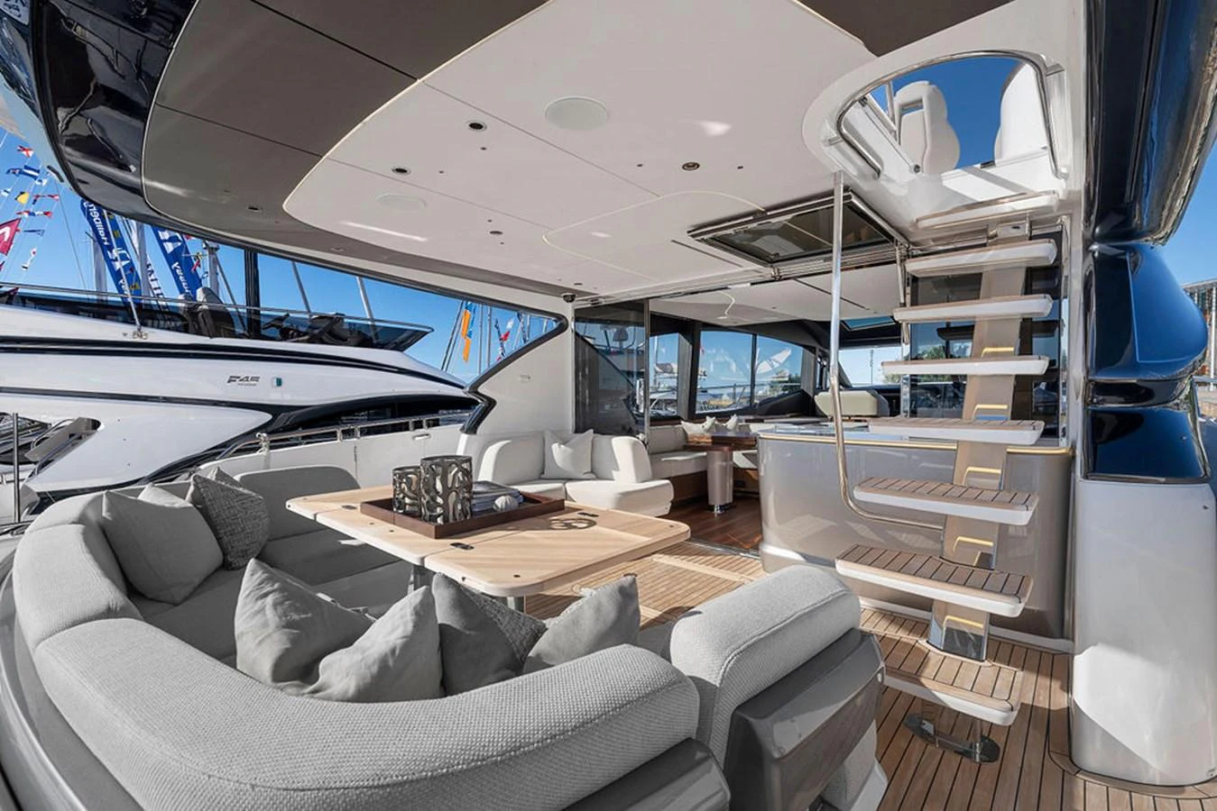 The aft deck features a luxurious seating area with a stylish staircase leading to the upper deck. aboard PRINCESS S72 Yacht for Sale