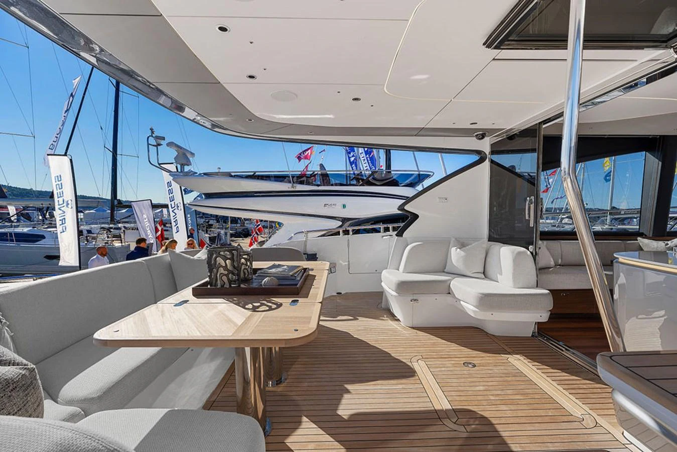 The aft deck features comfortable seating and a stylish dining area with a view of the marina. aboard PRINCESS S72 Yacht for Sale