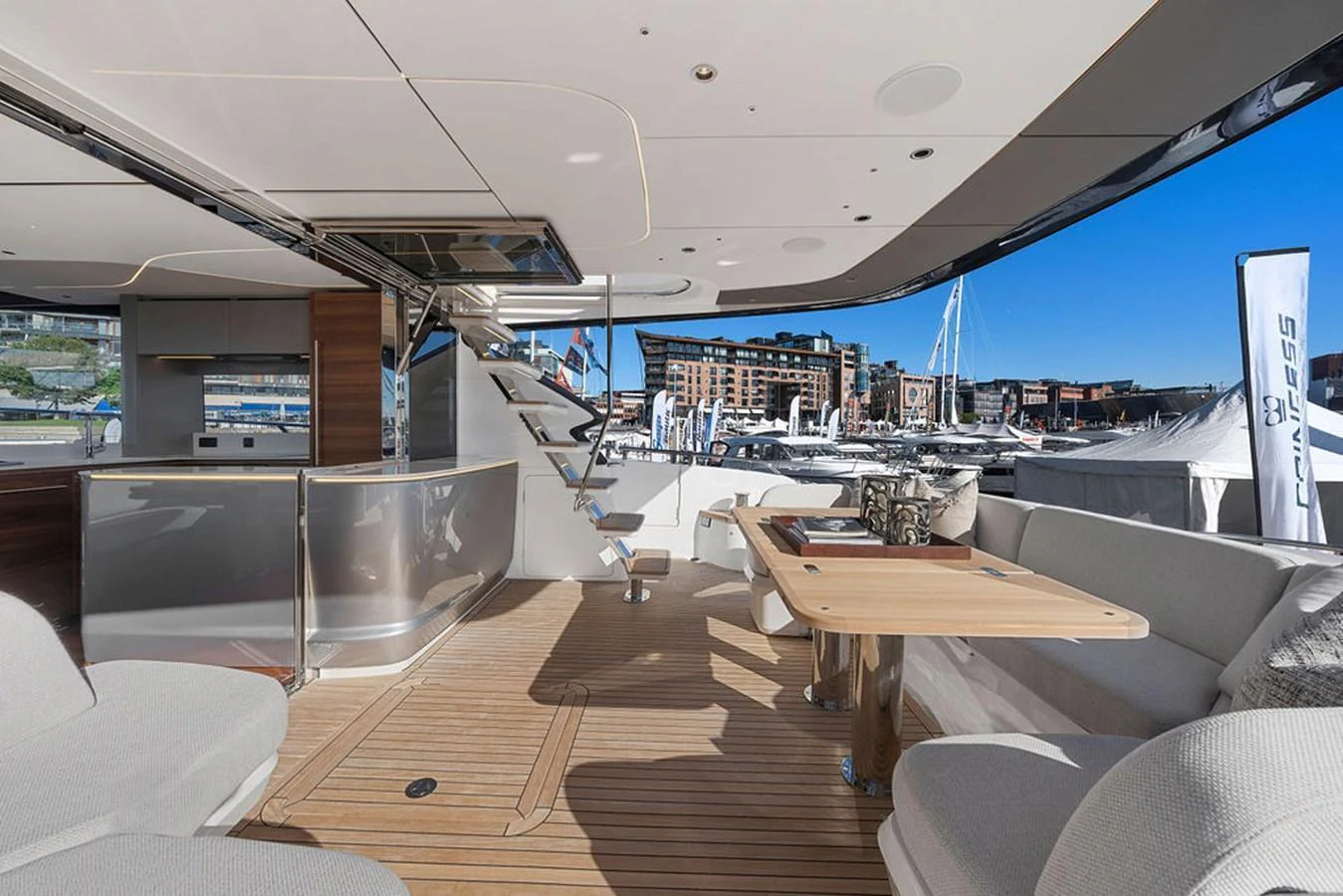 The aft deck offers a spacious and luxurious outdoor seating area with a view of the marina. aboard PRINCESS S72 Yacht for Sale