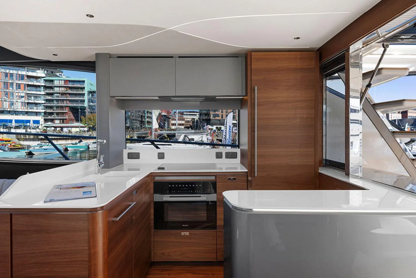 The modern galley features sleek cabinetry, high-end appliances, and ample counter space with a view of the marina. aboard PRINCESS S72 Yacht for Sale