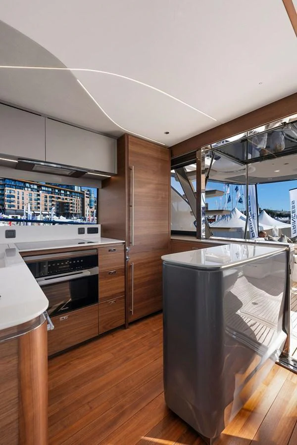 The yacht's galley features modern appliances and sleek wooden cabinetry, with ample natural light streaming in. aboard PRINCESS S72 Yacht for Sale