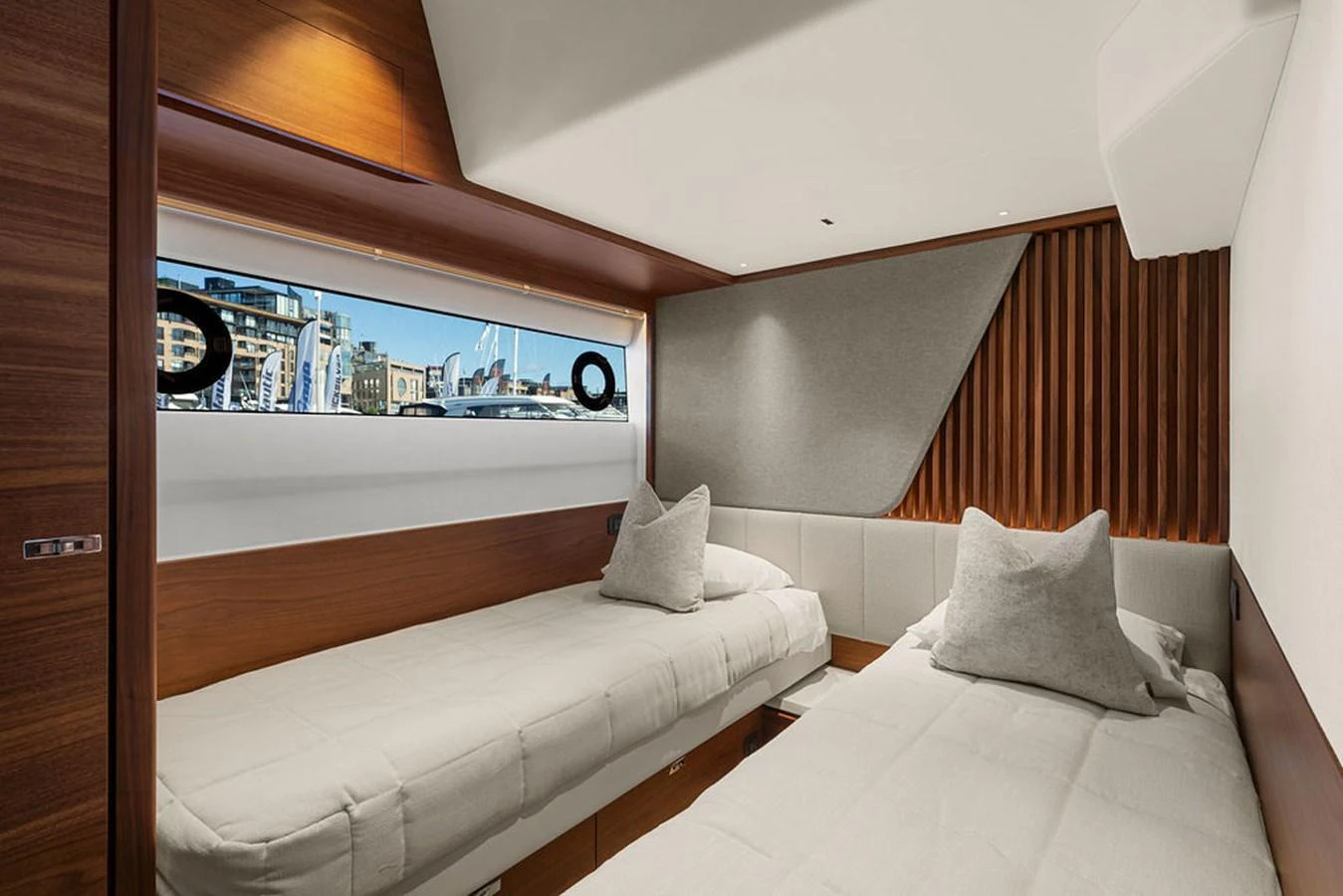The guest stateroom features twin beds with a modern, minimalist design and a large window offering a view of the marina. aboard PRINCESS S72 Yacht for Sale