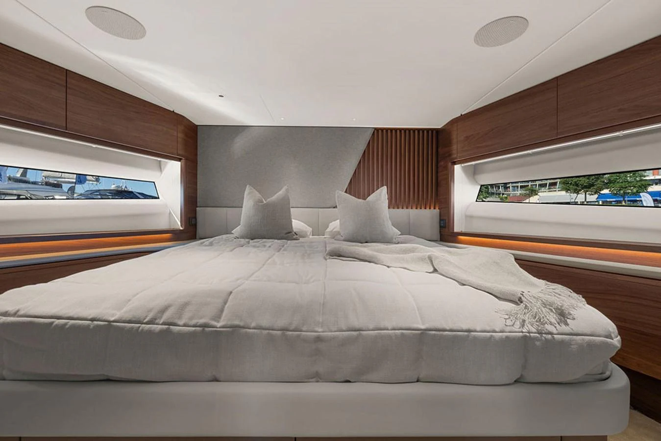 The stateroom features a luxurious bed with plush pillows and modern wooden accents. aboard PRINCESS S72 Yacht for Sale